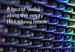 A tourist walks along the empty Hikkaduwa beach Powerpoint Presentation